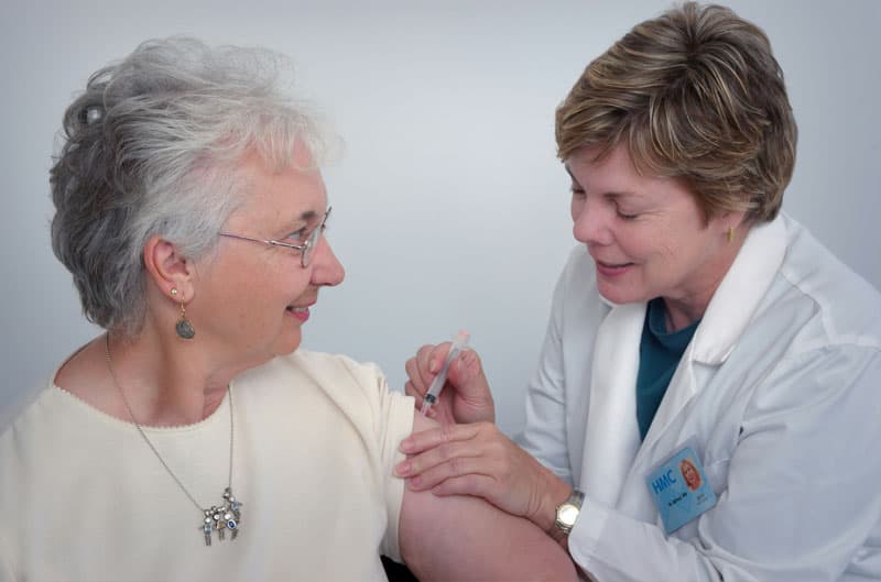 Elderly care nurse assisting a senior